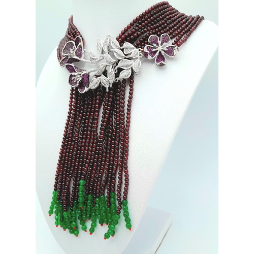 73 - A statement multi gem necklace consisting of eleven strands with a spectacular central floral pendan... 