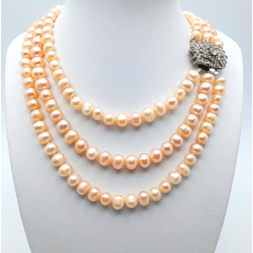 94 - A vintage three strand cultured natural pink pearls necklace with a stunning clasp loaded with cubic... 