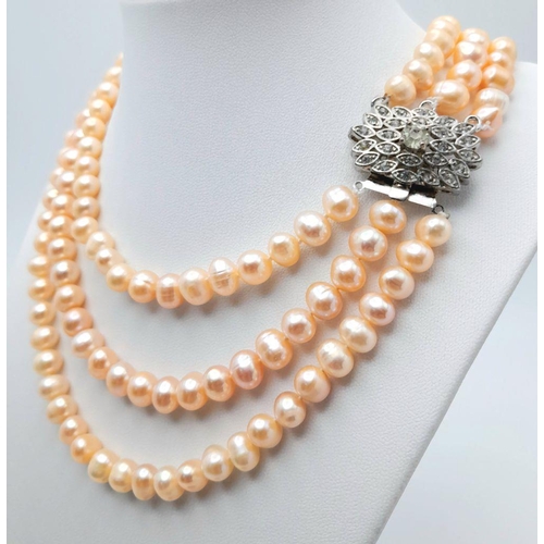 94 - A vintage three strand cultured natural pink pearls necklace with a stunning clasp loaded with cubic... 