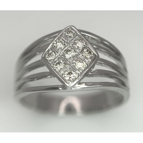 248 - An 18K White Gold Diamond Ring. Skeleton form with a trillion nine diamond centre. Size Q. 5.12g tot... 