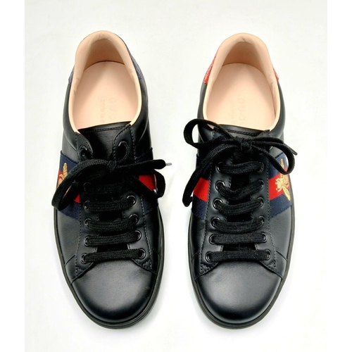 253 - A Pair of Gucci Men's Ace Embroidered Sneakers. Black leather with a gold embroidered bee to side. I... 