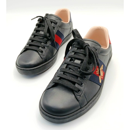 253 - A Pair of Gucci Men's Ace Embroidered Sneakers. Black leather with a gold embroidered bee to side. I... 