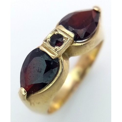 304 - AN 14K GOLD DESIGNER RING WITH UNUSUAL GARNET STONES  .            5.4gms    size Q