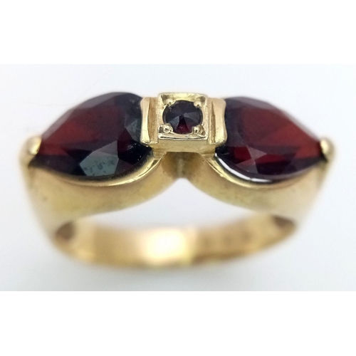 304 - AN 14K GOLD DESIGNER RING WITH UNUSUAL GARNET STONES  .            5.4gms    size Q