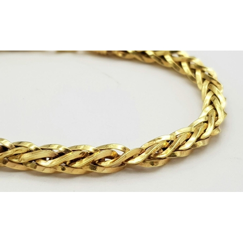 74 - AN 18K GOLD INTERLINK TWIST BRACELET WITH LOBSTER CLASP  .   8.1gms     20cms