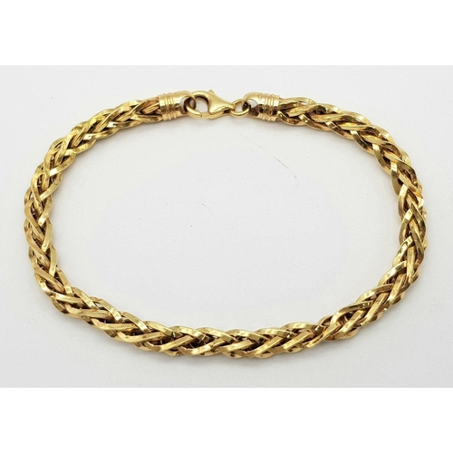 74 - AN 18K GOLD INTERLINK TWIST BRACELET WITH LOBSTER CLASP  .   8.1gms     20cms