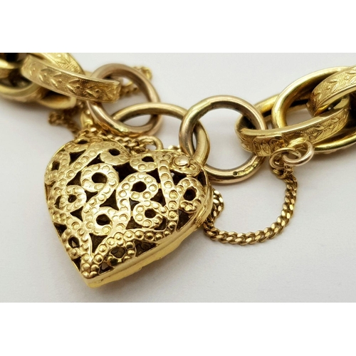 81 - A VINTAGE 9K GOLD HEAVY LINK BRACELT WITH EACH LINK BEING DECORATED AND HAVING AN ORNATE HEART PADLO... 