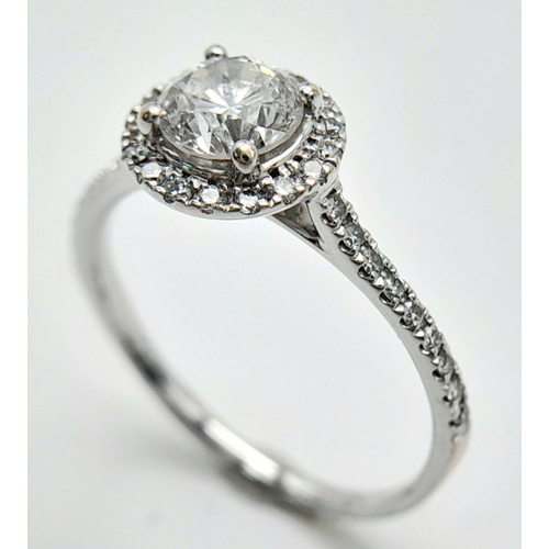 11 - AN 18K WHITE GOLD DIAMOND HALO SOLITAIRE RING 0.75CT MAIN STONE ROUND BRILIANT AND 0.25CT OF HALO & ... 