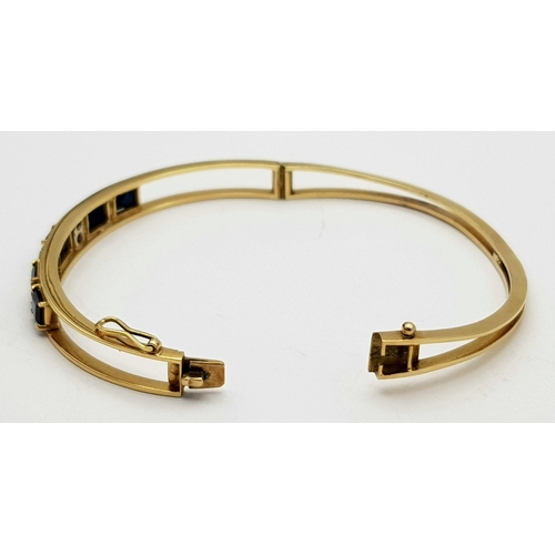 54 - A 14K (TESTED AS) YELLOW GOLD BANGLE SET WITH FIVE SAPPHIRES AND FOUR DIAMONDS, 6CM DIAMETER, 15.9G ... 