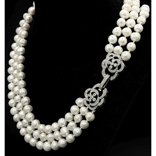 104 - A very glamorous set of a three-string pearl necklace and a bracelet with white natural cultured pea... 