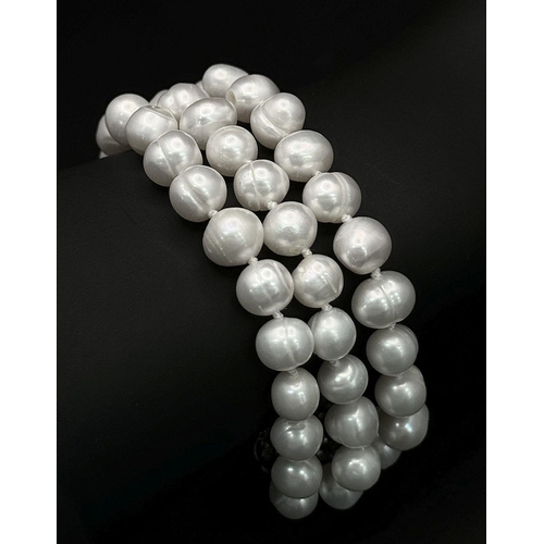 104 - A very glamorous set of a three-string pearl necklace and a bracelet with white natural cultured pea... 