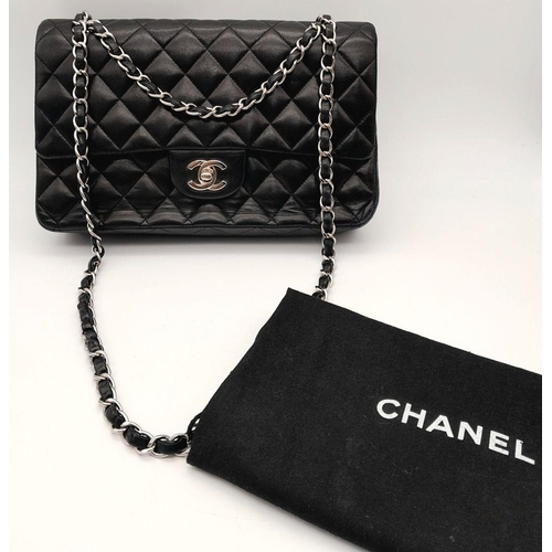 22 - A Chanel single flap crossbody bag in black lambskin leather. silver tone hardware, burgundy leather... 