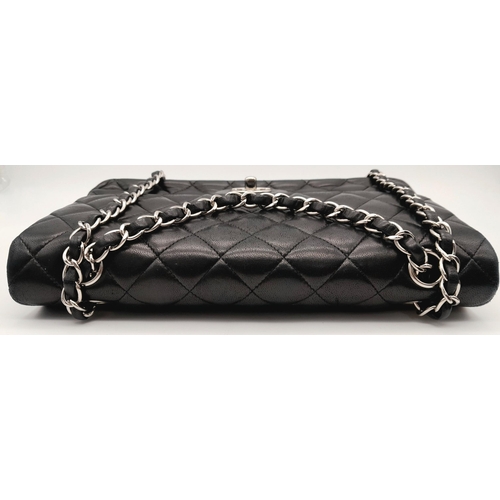 22 - A Chanel single flap crossbody bag in black lambskin leather. silver tone hardware, burgundy leather... 