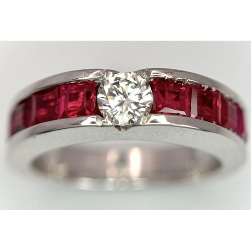 282 - An 18K White Gold Ruby and Diamond Ring. A central 0.25ct brilliant round cut diamond with four squa... 