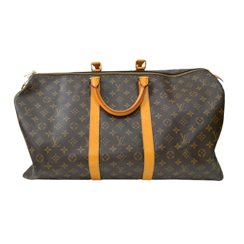 101 - A Louis Vuitton Keepall 55 Travel Bag. Monogram coated canvas exterior with leather trim, two rolled... 