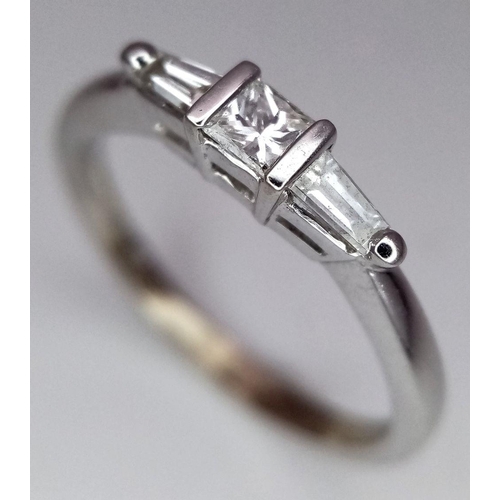 157 - AN 18K WHITE GOLD DIAMOND RING - PRINCESS CUT CENTRE WITH TAPPERED BAGUETTE SHOULDERS. 0.35CT TOTAL.... 