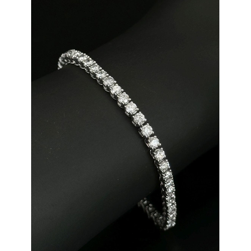 4 - AN 18K WHITE GOLD DIAMOND SET TENNIS BRACELET -5CTW APPROX OF BRILLIANT ROUND CUT DIAMONDS. 12.8G TO... 