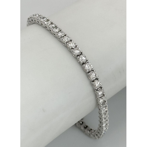 4 - AN 18K WHITE GOLD DIAMOND SET TENNIS BRACELET -5CTW APPROX OF BRILLIANT ROUND CUT DIAMONDS. 12.8G TO... 