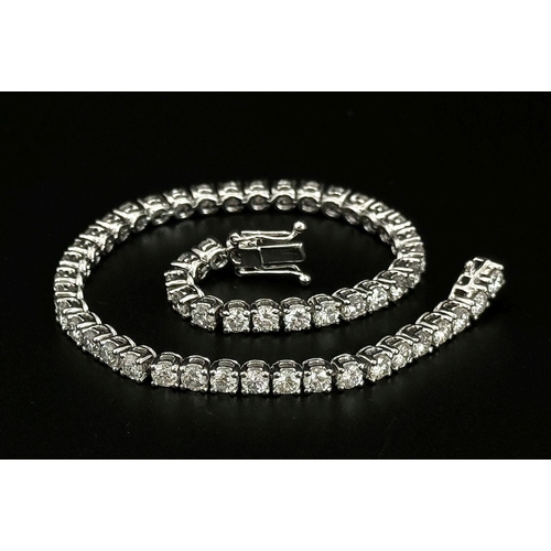 4 - AN 18K WHITE GOLD DIAMOND SET TENNIS BRACELET -5CTW APPROX OF BRILLIANT ROUND CUT DIAMONDS. 12.8G TO... 