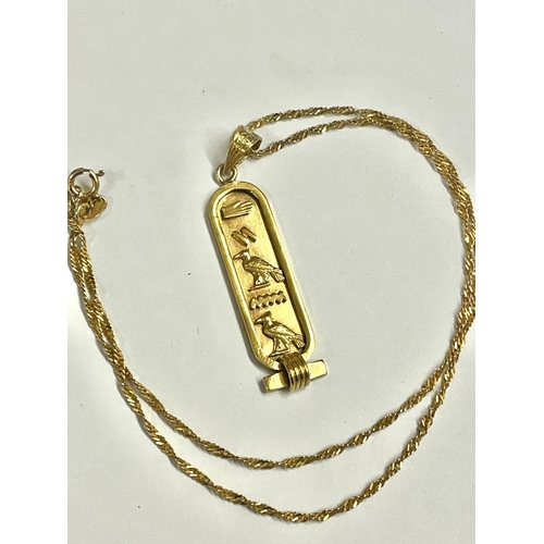 977 - A 9ct gold chain with gilt Egyptian cartouche pendant . Chain is 14 inch length.