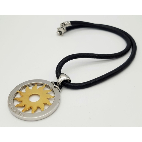 51 - A Bulgari Steel and 18K Yellow Gold Sun Pendant. 4.5cm diameter.  Textile necklace. Comes with origi... 