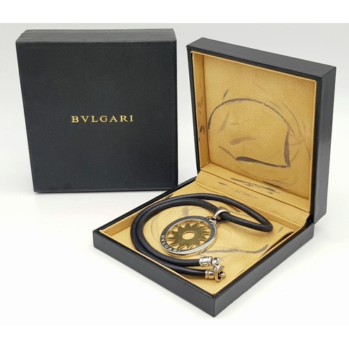 51 - A Bulgari Steel and 18K Yellow Gold Sun Pendant. 4.5cm diameter.  Textile necklace. Comes with origi... 