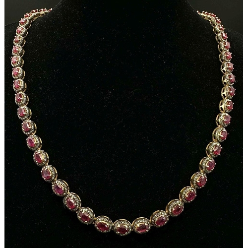 163 - A Ruby and Diamond Tennis Necklace and Drop Earrings Set. Oval cut deep red rubies each with an old ... 