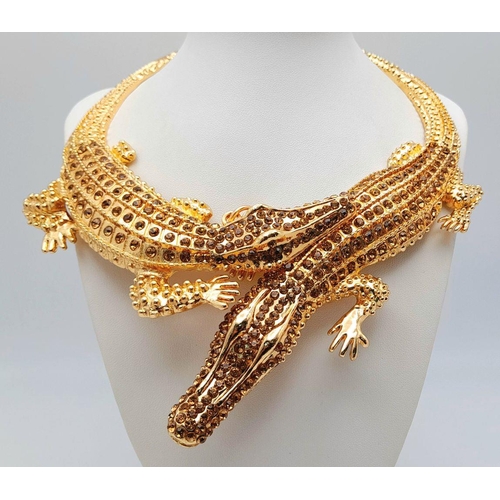 168 - A statement necklace with two gold plated overlapping crocodiles covered with yellow diamante. For t... 