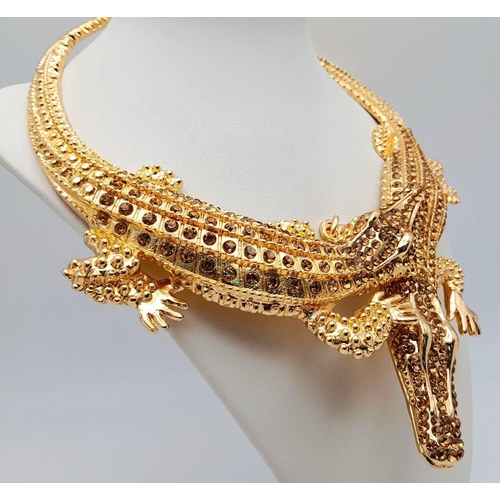 168 - A statement necklace with two gold plated overlapping crocodiles covered with yellow diamante. For t... 