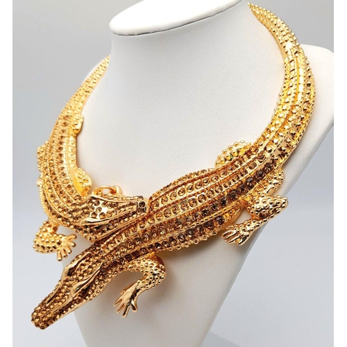 168 - A statement necklace with two gold plated overlapping crocodiles covered with yellow diamante. For t... 