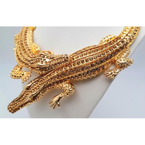 168 - A statement necklace with two gold plated overlapping crocodiles covered with yellow diamante. For t... 