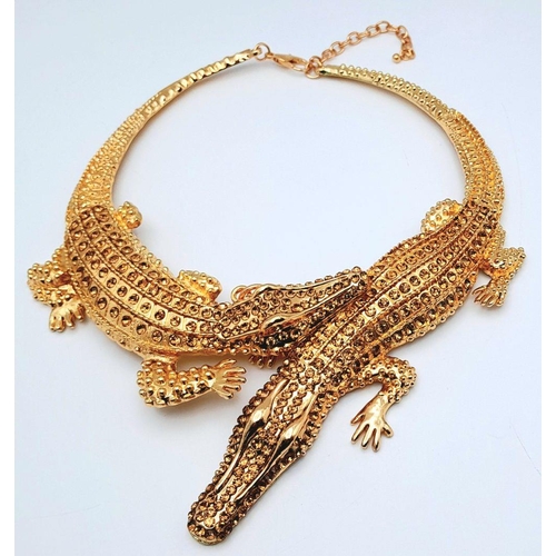 168 - A statement necklace with two gold plated overlapping crocodiles covered with yellow diamante. For t... 