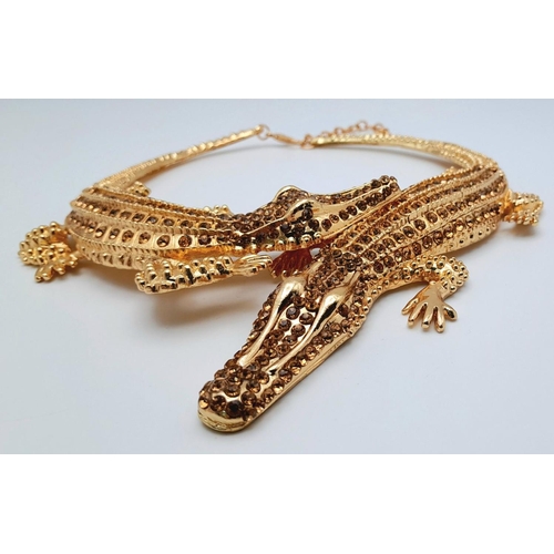 168 - A statement necklace with two gold plated overlapping crocodiles covered with yellow diamante. For t... 