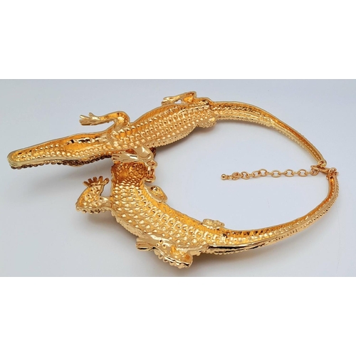 168 - A statement necklace with two gold plated overlapping crocodiles covered with yellow diamante. For t... 