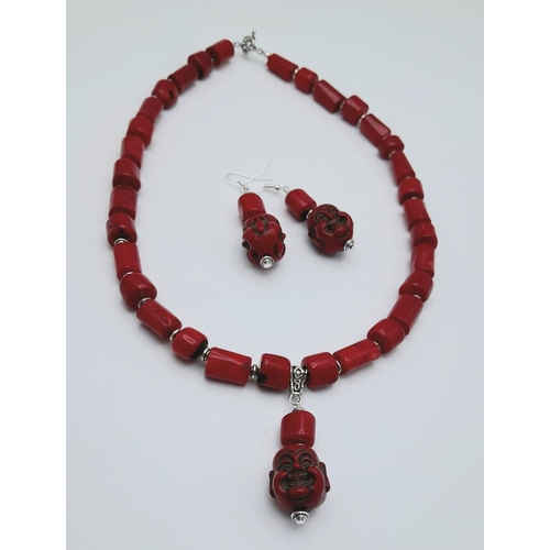 210 - A substantial, chunky, Pacific red coral necklace and earrings set with smiling Buddha head pendants... 