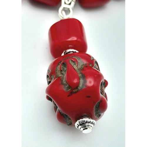 210 - A substantial, chunky, Pacific red coral necklace and earrings set with smiling Buddha head pendants... 