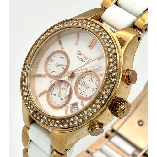 231 - A rose gold plated, Ceramic DKNY Chronometer watch, 38 mm case, bezel with cubic zirconia, white dia... 