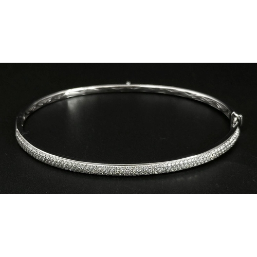 32 - AN 18K WHITE GOLD DIAMOND SET BANGLE. 1.20CTW. 9G. CLIP DESIGN. 6CM INNER DIAMETER. SC3024.