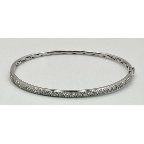 32 - AN 18K WHITE GOLD DIAMOND SET BANGLE. 1.20CTW. 9G. CLIP DESIGN. 6CM INNER DIAMETER. SC3024.