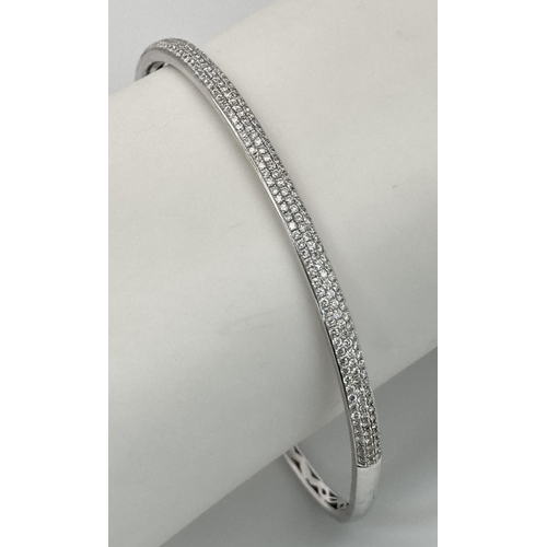 32 - AN 18K WHITE GOLD DIAMOND SET BANGLE. 1.20CTW. 9G. CLIP DESIGN. 6CM INNER DIAMETER. SC3024.