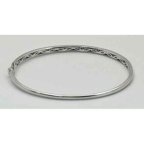 32 - AN 18K WHITE GOLD DIAMOND SET BANGLE. 1.20CTW. 9G. CLIP DESIGN. 6CM INNER DIAMETER. SC3024.