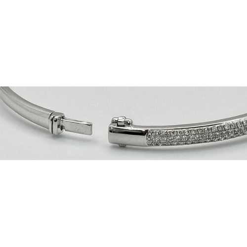 32 - AN 18K WHITE GOLD DIAMOND SET BANGLE. 1.20CTW. 9G. CLIP DESIGN. 6CM INNER DIAMETER. SC3024.