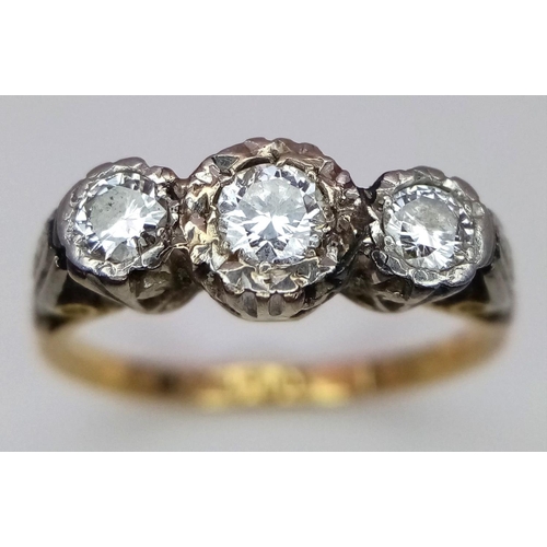 43 - An Antique 18K Yellow Gold and Three Stone Diamond Ring. Three European old cut diamonds in a platin... 