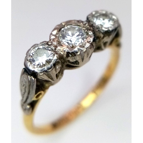 43 - An Antique 18K Yellow Gold and Three Stone Diamond Ring. Three European old cut diamonds in a platin... 