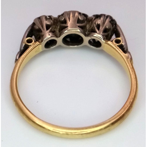 43 - An Antique 18K Yellow Gold and Three Stone Diamond Ring. Three European old cut diamonds in a platin... 