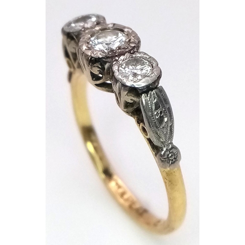 43 - An Antique 18K Yellow Gold and Three Stone Diamond Ring. Three European old cut diamonds in a platin... 