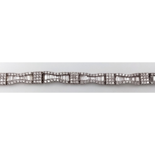 5 - AN 18K WHITE GOLD AND DIAMOND FANCY TENNIS BRACELET. BOW TIE BAGUETTE DIAMOND SHAPES WITH ROUND CUT ... 