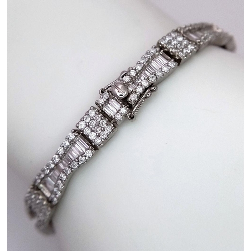 5 - AN 18K WHITE GOLD AND DIAMOND FANCY TENNIS BRACELET. BOW TIE BAGUETTE DIAMOND SHAPES WITH ROUND CUT ... 