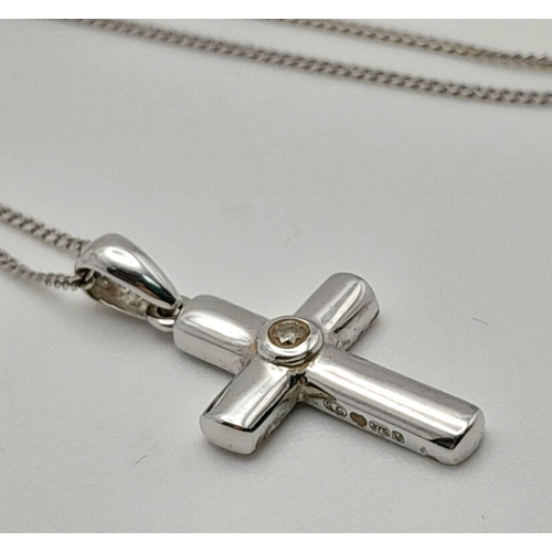 146 - Elegant and dainty 9 carat WHITE GOLD CROSS with CENTRE DIAMOND. Mounted on a fine 9 carat WHITE GOL... 