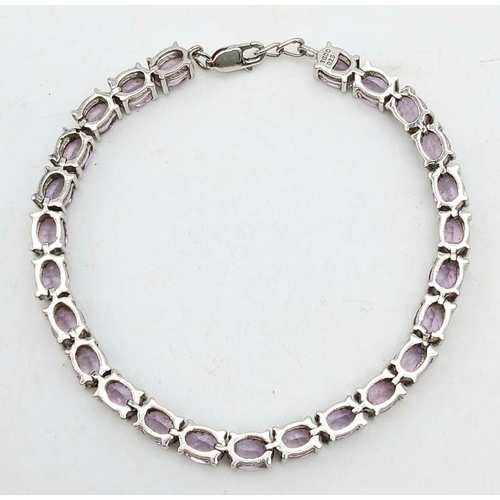 598 - A Sterling Silver Round Cut Amethyst Tennis Bracelet. 20cm Length. Set with 5mm Round Cut Amethysts.... 